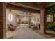 Covered outdoor patio with stone pillars, comfortable seating, and a view into the house at 48 Panorama Crest Ave, Las Vegas, NV 89135