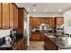 Gourmet kitchen featuring wood cabinetry, stainless appliances, and granite countertops at 48 Panorama Crest Ave, Las Vegas, NV 89135