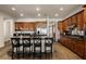 Kitchen with wood cabinetry, black granite island, stainless appliances, and tiled floor at 48 Panorama Crest Ave, Las Vegas, NV 89135