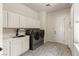 Well-equipped laundry room with ample cabinet space, sink, and modern appliances at 48 Panorama Crest Ave, Las Vegas, NV 89135