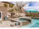 Inviting backyard pool and spa featuring a rock waterfall, desert landscaping, and tranquil seating area at 48 Panorama Crest Ave, Las Vegas, NV 89135