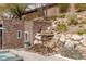 Backyard waterfall feature with natural rock and desert plants, creating a tranquil escape by the pool at 48 Panorama Crest Ave, Las Vegas, NV 89135