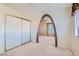 Carpeted bedroom with sliding door closet and unique brick archway to the living area at 501 Starfire Pl, Las Vegas, NV 89107