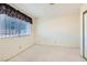 Bright bedroom featuring carpet floors and a window with blinds and decorative curtains at 501 Starfire Pl, Las Vegas, NV 89107