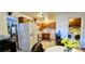 Cozy kitchen featuring wood cabinets, white appliances, tile floors, and adjacent laundry room at 501 Starfire Pl, Las Vegas, NV 89107