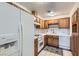 Functional kitchen features white appliances, and tile countertops with oak cabinets at 501 Starfire Pl, Las Vegas, NV 89107