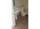 Modest bathroom features a pedestal sink, tiled flooring and a standard toilet at 5213 Castle Butte Ct, North Las Vegas, NV 89031