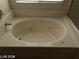 A pristine white jetted bathtub with tile surround and chrome faucet at 5213 Castle Butte Ct, North Las Vegas, NV 89031