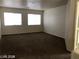 Open living room with carpet floors and natural light from large windows at 5213 Castle Butte Ct, North Las Vegas, NV 89031