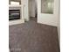 Open living room with fireplace, plush carpeting, and ample natural light at 5213 Castle Butte Ct, North Las Vegas, NV 89031