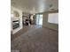 Open living space with fireplace, kitchen view, and natural light from sliding glass door at 5213 Castle Butte Ct, North Las Vegas, NV 89031