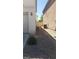 Narrow side yard with gravel featuring efficient AC units and a partial view of backyard fence at 5213 Castle Butte Ct, North Las Vegas, NV 89031