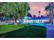 An inviting backyard with a lush lawn, mature trees, and a sparkling pool enhance outdoor living at 5239 Somerset Dr, Las Vegas, NV 89120