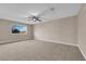 Carpeted main bedroom featuring a ceiling fan, large window, and neutral walls at 5239 Somerset Dr, Las Vegas, NV 89120