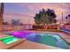 Backyard pool with outdoor lighting, shed, and tree against colorful dusk sky at 5239 Somerset Dr, Las Vegas, NV 89120