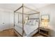 Bright bedroom featuring a four-poster bed, modern nightstand, and artful decor at 541 Green Sage Way, Las Vegas, NV 89138