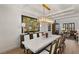 Open-concept dining room with a marble dining table and modern chandelier lighting at 541 Green Sage Way, Las Vegas, NV 89138