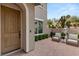 Inviting front entrance with a beautifully crafted wooden door and charming courtyard setting with seating at 541 Green Sage Way, Las Vegas, NV 89138