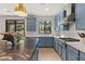 Modern kitchen showcasing stainless steel appliances, granite counters, and blue cabinetry at 541 Green Sage Way, Las Vegas, NV 89138