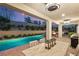 Covered patio with dining table overlooking the pool, and an outdoor kitchen at 541 Green Sage Way, Las Vegas, NV 89138