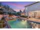 Backyard pool and patio with comfortable seating, a relaxing fire pit, and lush greenery at 541 Green Sage Way, Las Vegas, NV 89138