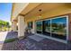 This covered back patio features stone pavers, large sliding doors, and a view of the greenbelt at 5524 E San Pietro Dr, Pahrump, NV 89061