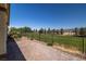 Expansive backyard featuring well-maintained lawn with mature trees and landscaping offering scenic views beyond the fence at 5524 E San Pietro Dr, Pahrump, NV 89061