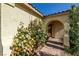 Arched entryway adorned with vibrant roses, leading to the inviting front door of this charming home at 5524 E San Pietro Dr, Pahrump, NV 89061