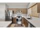 Modern kitchen featuring stainless steel appliances, tile backsplash, and light wood cabinets at 5524 E San Pietro Dr, Pahrump, NV 89061