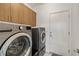 This laundry room includes a washer, dryer, and functional cabinets for storage at 5524 E San Pietro Dr, Pahrump, NV 89061