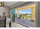 View of covered patio with outdoor fireplace, brick flooring, and landscaped backyard through sliding glass doors at 5524 E San Pietro Dr, Pahrump, NV 89061