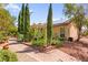 Landscaped backyard with mature trees and greenery offering privacy and shade at 5612 Beach Mill Way, Las Vegas, NV 89130