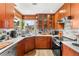 Modern kitchen featuring wood cabinetry, stainless steel appliances, countertops and natural light from the window at 5612 Beach Mill Way, Las Vegas, NV 89130