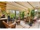 Outdoor living space with shade, comfortable seating, and surrounding greenery at 5612 Beach Mill Way, Las Vegas, NV 89130