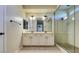 Bright bathroom with double sinks, modern vanity, large mirror, and walk-in glass shower at 5697 Garriga Dr, Las Vegas, NV 89135