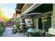 Covered patio featuring outdoor dining set, lush greenery, and stone accents at 5697 Garriga Dr, Las Vegas, NV 89135