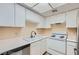 This kitchen offers all-white appliances and cabinetry, with tile flooring at 5913 Smoke Ranch Rd # A, Las Vegas, NV 89108