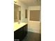 Bathroom featuring a vanity with black cabinets, bathtub, and a window at 6528 Chebec St, North Las Vegas, NV 89084