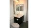 Bathroom with a vanity that has dark cabinets, toilet, and mirror at 6528 Chebec St, North Las Vegas, NV 89084