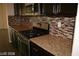 Contemporary kitchen showcasing stainless steel gas range and oven with granite countertops and tile backsplash at 6528 Chebec St, North Las Vegas, NV 89084