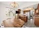 Spacious dining room flowing into kitchen, featuring a vintage chandelier and ample natural light at 7008 Brown Derby Circle Dr, Las Vegas, NV 89128