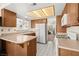 Traditional kitchen with wood cabinets, white appliances, and view to next room at 7008 Brown Derby Circle Dr, Las Vegas, NV 89128
