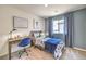 Comfortable bedroom featuring a wooden bed frame, blue accent wall, and a functional desk area at 7441 Bosco Brook # 104, North Las Vegas, NV 89084