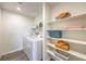 Well-organized laundry room with modern washer/dryer and ample shelving for storage at 7441 Bosco Brook # 104, North Las Vegas, NV 89084