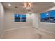 Bedroom featuring neutral walls, carpet flooring, two windows providing ample natural light, and an ensuite bathroom at 7521 Prancing Pony Ct, Las Vegas, NV 89131