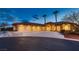 Stunning exterior view of the desert home with a circular driveway and palm trees at 7521 Prancing Pony Ct, Las Vegas, NV 89131