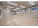 Spacious garage with epoxy flooring, ample lighting, multiple outlets, and a large roll-up door at 7521 Prancing Pony Ct, Las Vegas, NV 89131