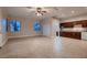 Expansive living room with tile flooring, neutral walls, a ceiling fan, and an open layout leading to the kitchen at 7521 Prancing Pony Ct, Las Vegas, NV 89131