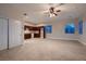 Spacious living room featuring tile flooring, neutral walls, ample natural light, and an adjacent kitchen area at 7521 Prancing Pony Ct, Las Vegas, NV 89131
