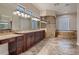 Elegant bathroom featuring double vanity sinks, glass shower, and garden tub at 7521 Prancing Pony Ct, Las Vegas, NV 89131